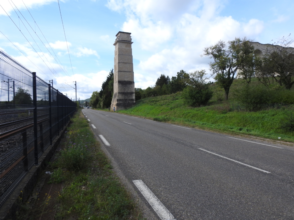 een enkele kolom, langs de weg en spoorlijn.